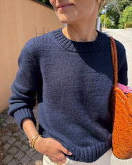 Kvinde iført blå Vega Sweater