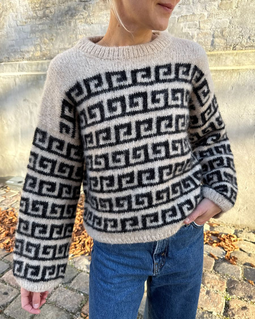 Kvinde iført beige og sort Athene Sweater tæt på