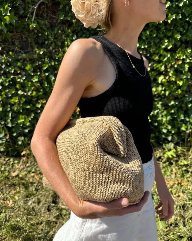 Cleo clutch med stor frame holdes af kvinde 