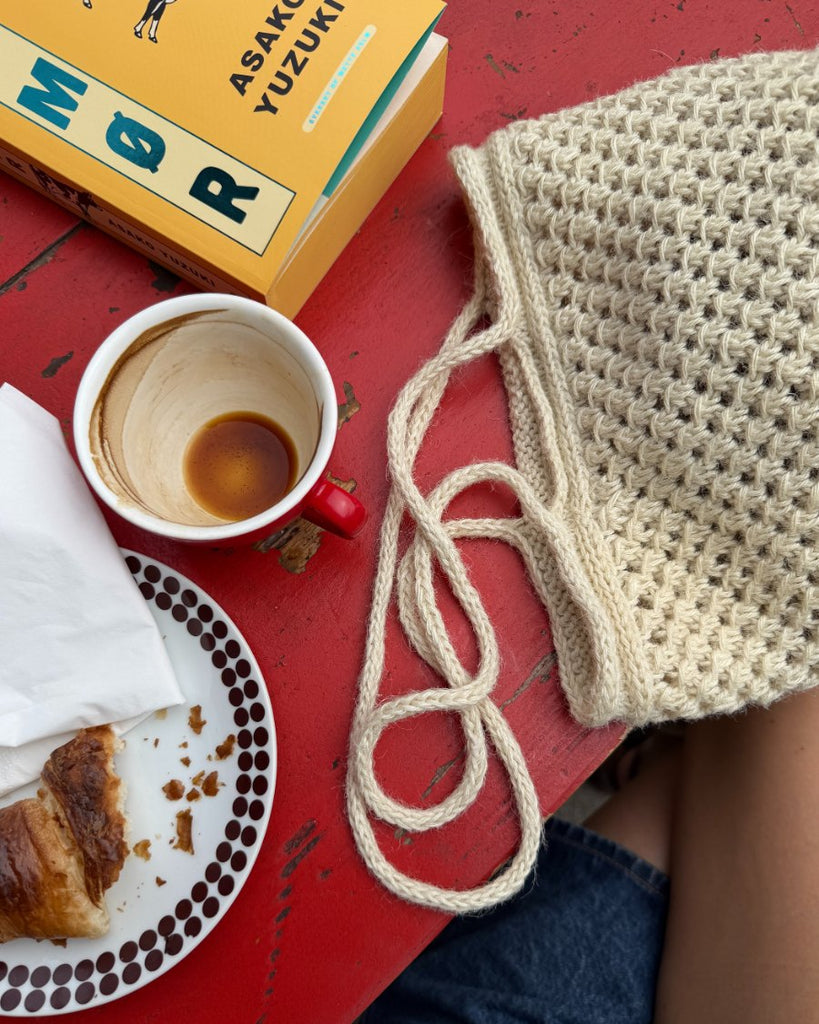 Hvid Como Bag liggende på cafébord set tæt på