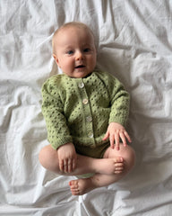 Baby iført grønt Ellens Legsæt