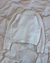 Hvid Ingen Dikkedarer Sweater liggende på sengetøj