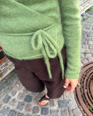 Kvinde iført grøn Lucy Wrap med fokus på bindebåndet