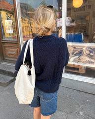 Kvinde iført blå Moby Sweater set bagfra