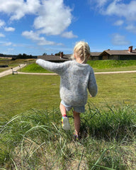 Barn iført nistret lyseblå Monday Sweater Junior 
