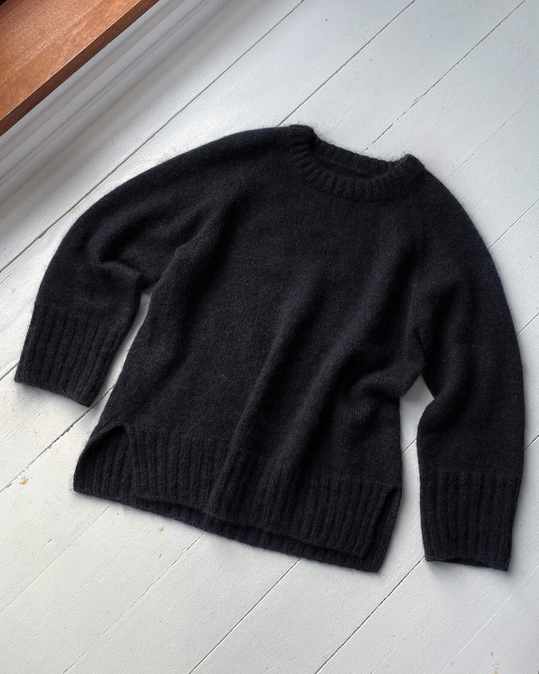 Kvinde iført sort October Sweater