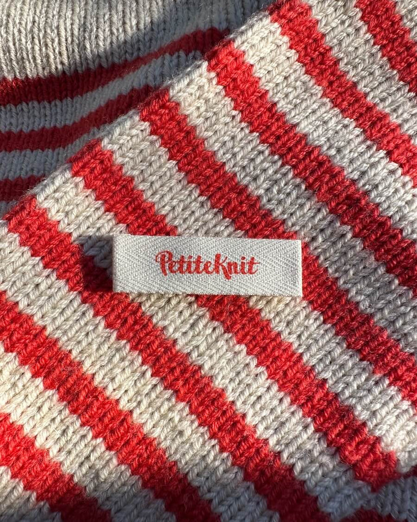 Petiteknit label med rød skrift 