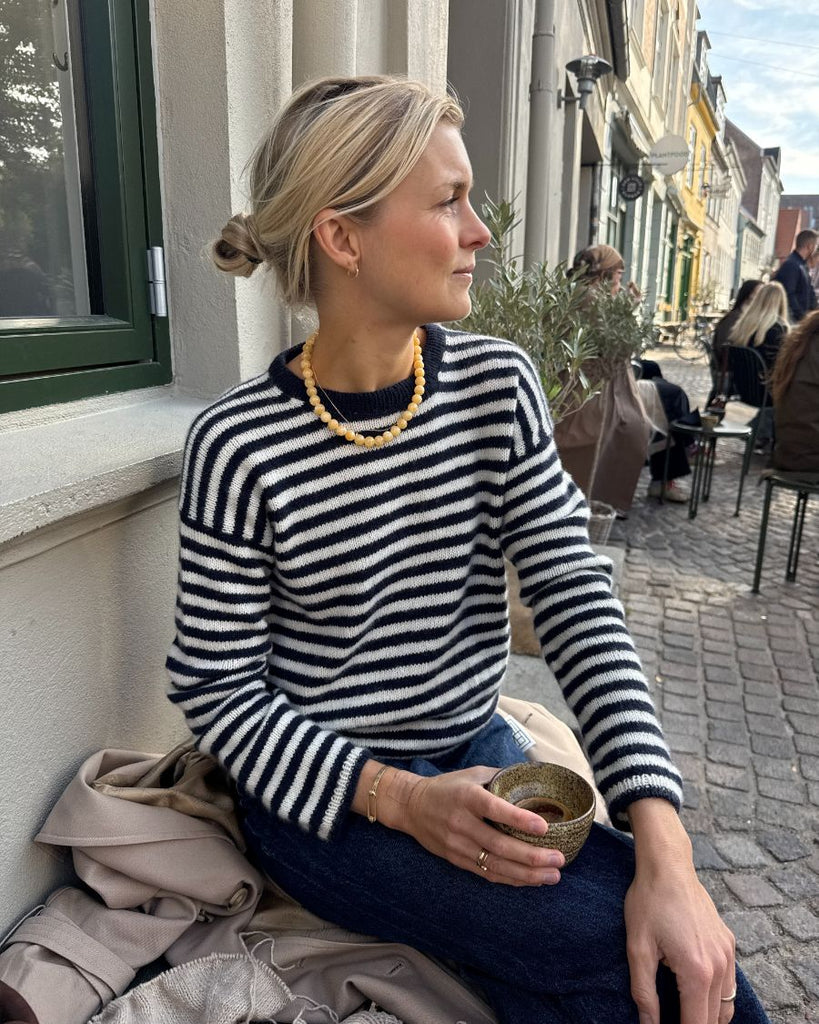 Kvinde iført hvid og blå Olga Blouse