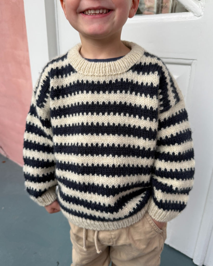Barn iført blå og hvid Otto Sweater Junior