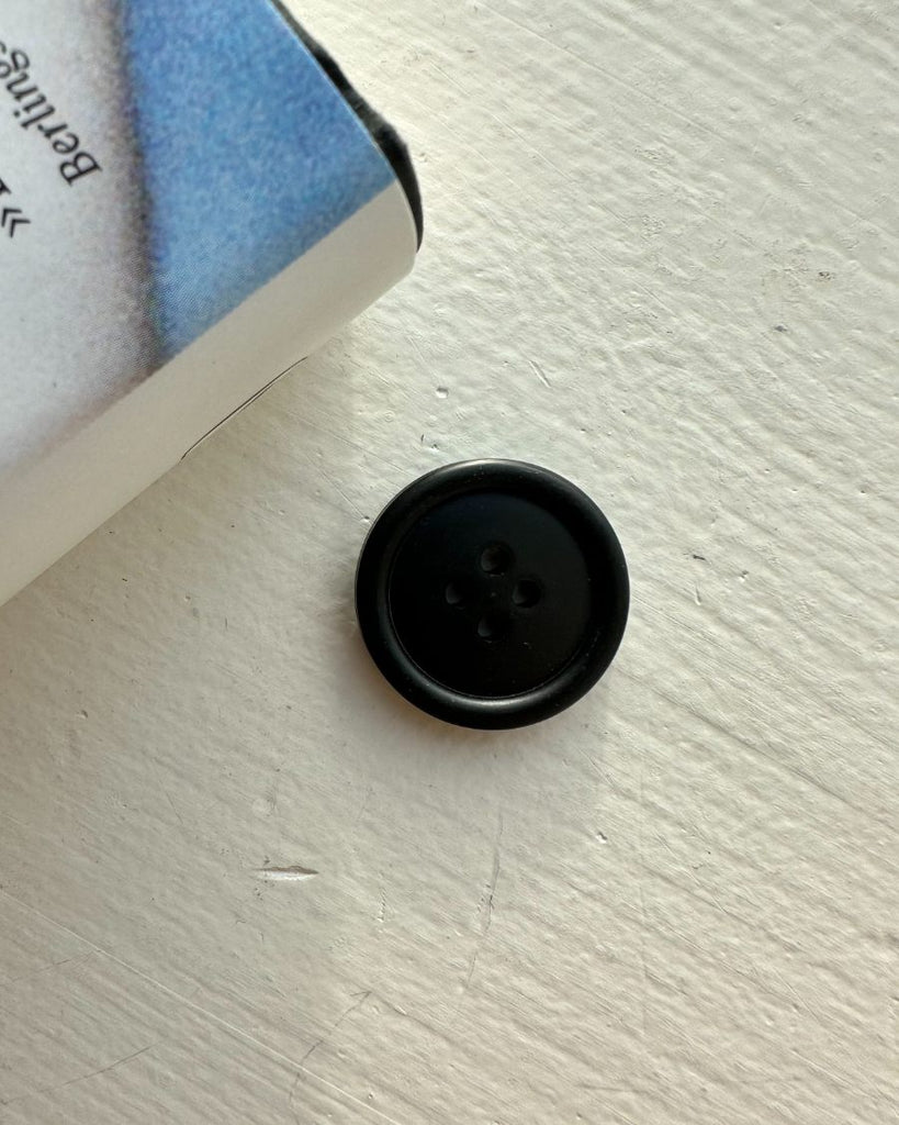 Én sort galalit knap Ø 23 mm