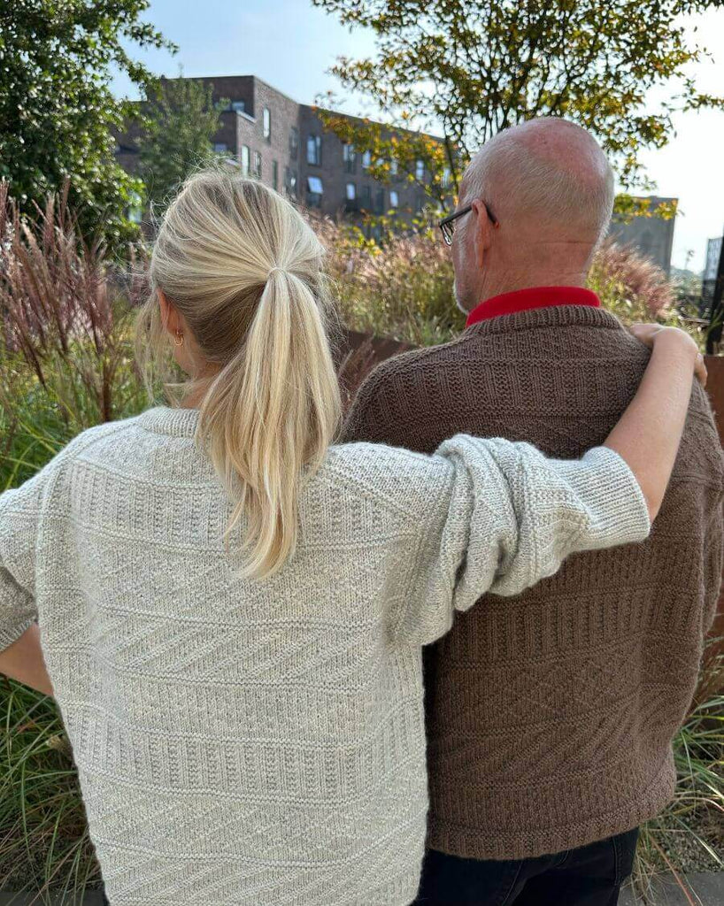 Mand iført brun Storm Sweater Man og kvinde iført lysegrå Storm Sweater set fra ryggen