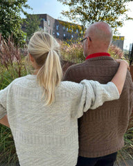Mand iført brun Storm Sweater Man og kvinde iført lysegrå Storm Sweater set fra ryggen