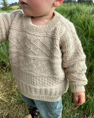 Barn iført lys beige Storm Sweater Junior 