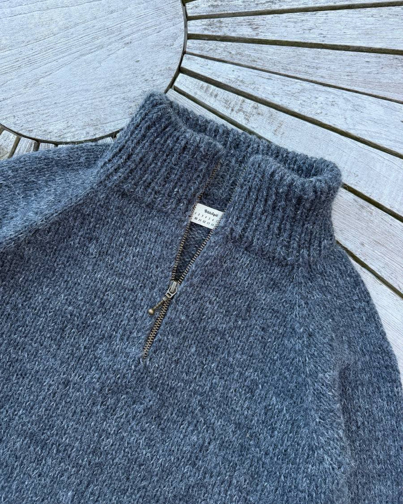Møkegrå Zipper Sweater Junior liggende på havebord