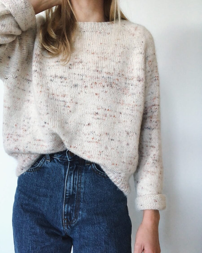 Kvinde iført hvidnistret Ingen Dikkedarer Sweater 