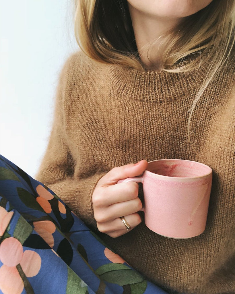 Closeup af kvinde iført kamelfarvet Stockholm Sweater 