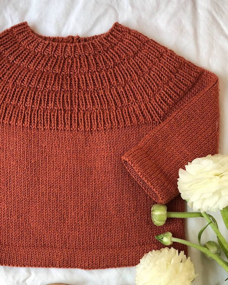 Closeup af liggende barn i lilla Ankers Bluse