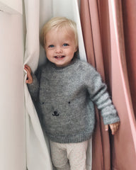 Barn iført grå Bamsesweater 