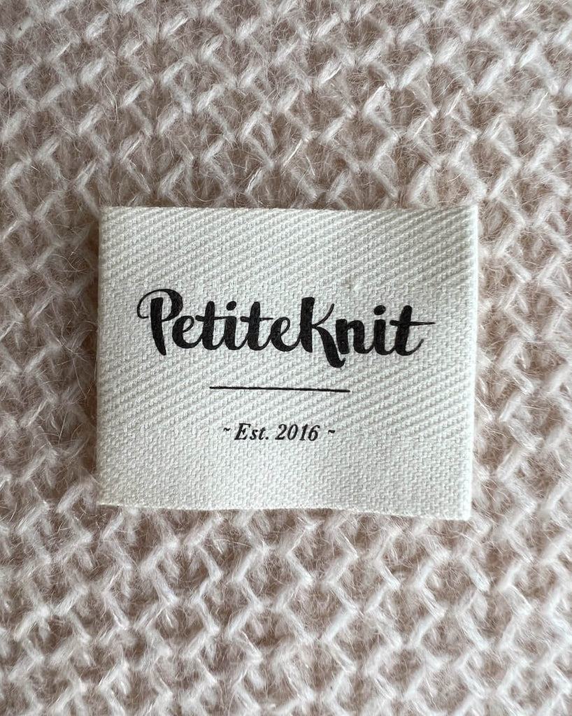 "PetiteKnit - Est. 2016" tekstillabel i økologisk bomuld 