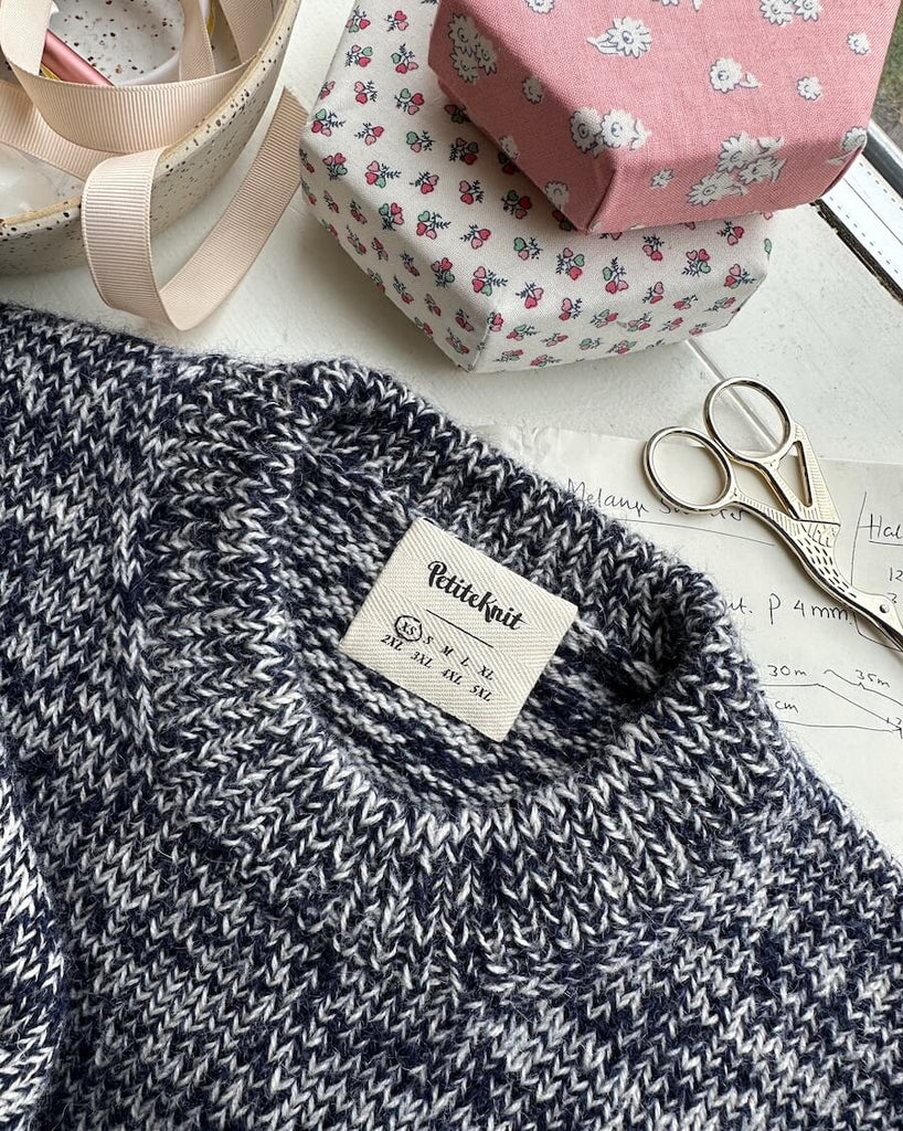 Label med størrelser i nakken på melange sweater