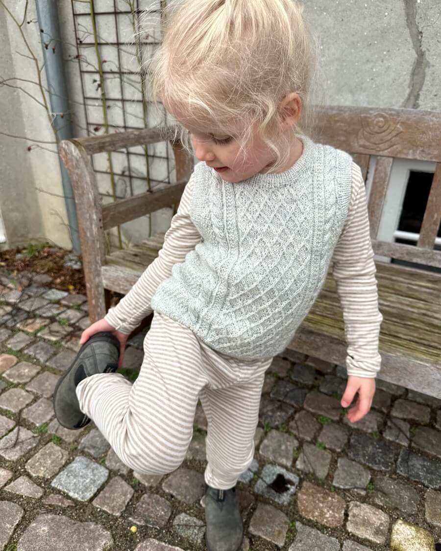 Barn iført lysegrå Moby Slipover Mini