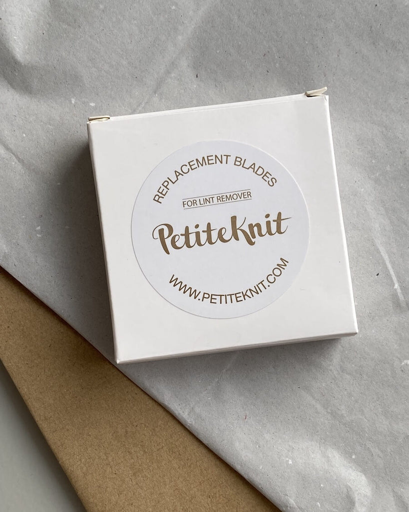 Skæreblade i hvid firkantet indpakning med logo klistermærke