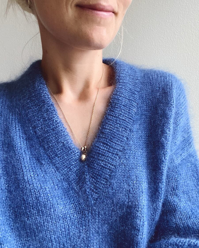 Detaljebillede af kvinde iført blå Stockholm Sweater V-neck