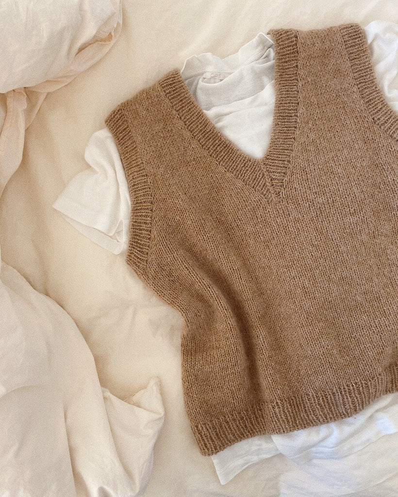 Liggebillede af beige Stockholm Slipover V-neck med hvid t-shirt under